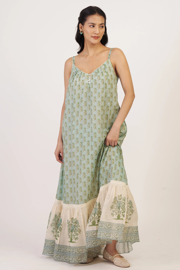 Woman wearing a green and white dress with a plain background
