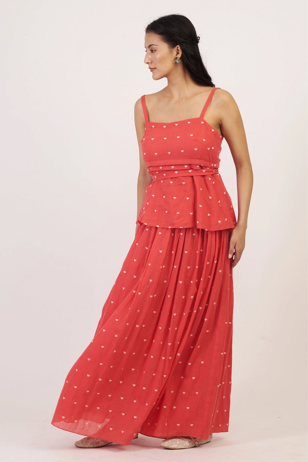 Woman wearing a red polka dot dress on a white background