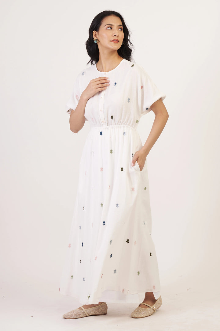 Woman wearing a white dress with black polka dots on a white background