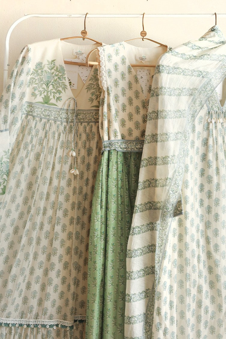 Traditional Indian attire with green and white patterns on a rack.